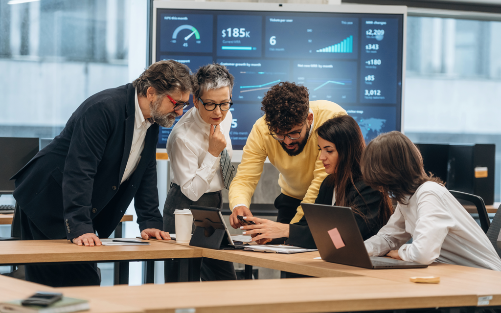 University team working on improvement plan using dashboards and reports; collaborative environment with charts and performance insights; focus on strategy, planning, and institutional growth